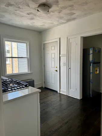 a view of a room with wooden floor and white walls