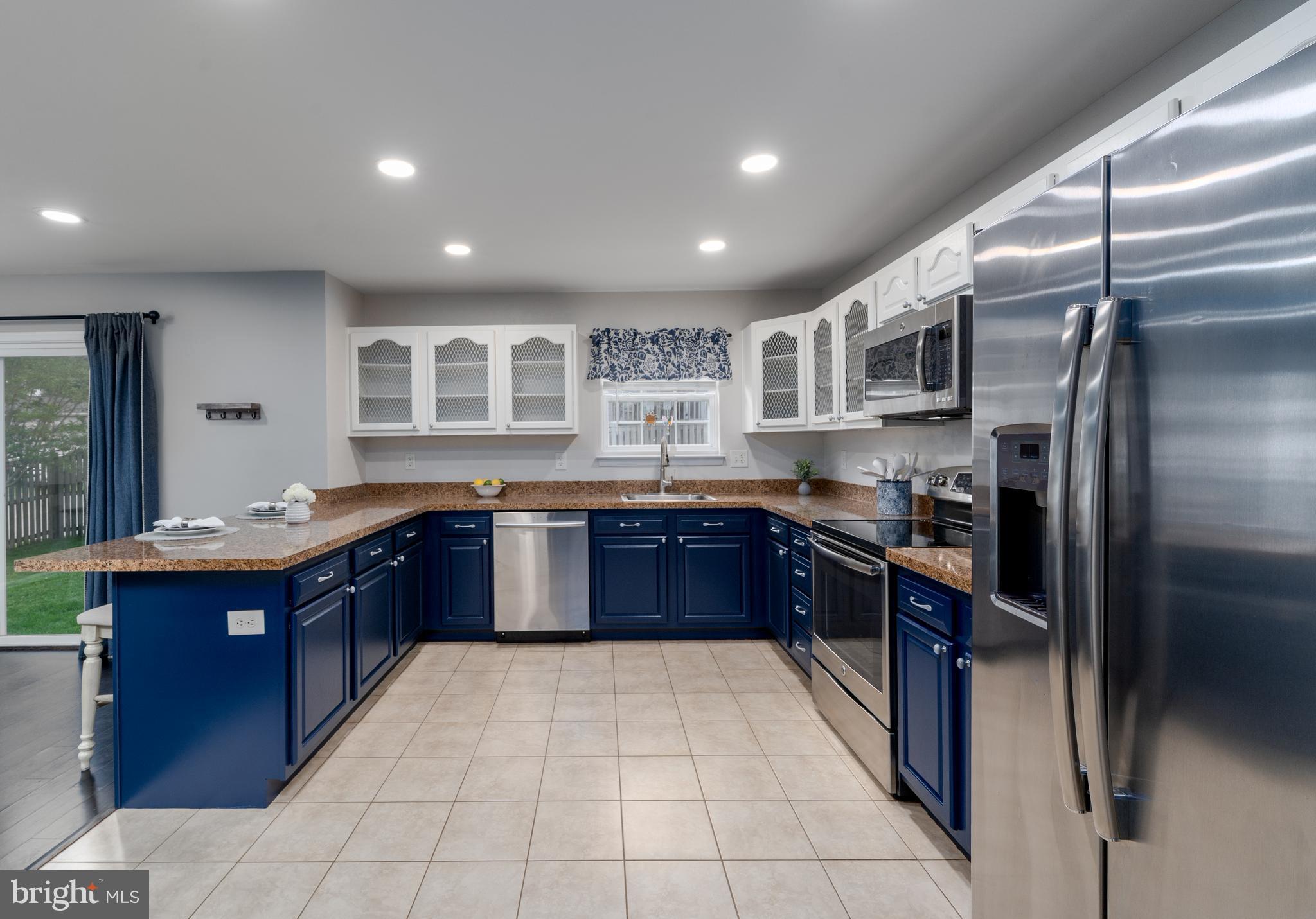 7815 Outing Avenue Pasadena, MD 21122 - Photo 11 of 37 a large kitchen with granite countertop a large stove a refrigerator and a sink