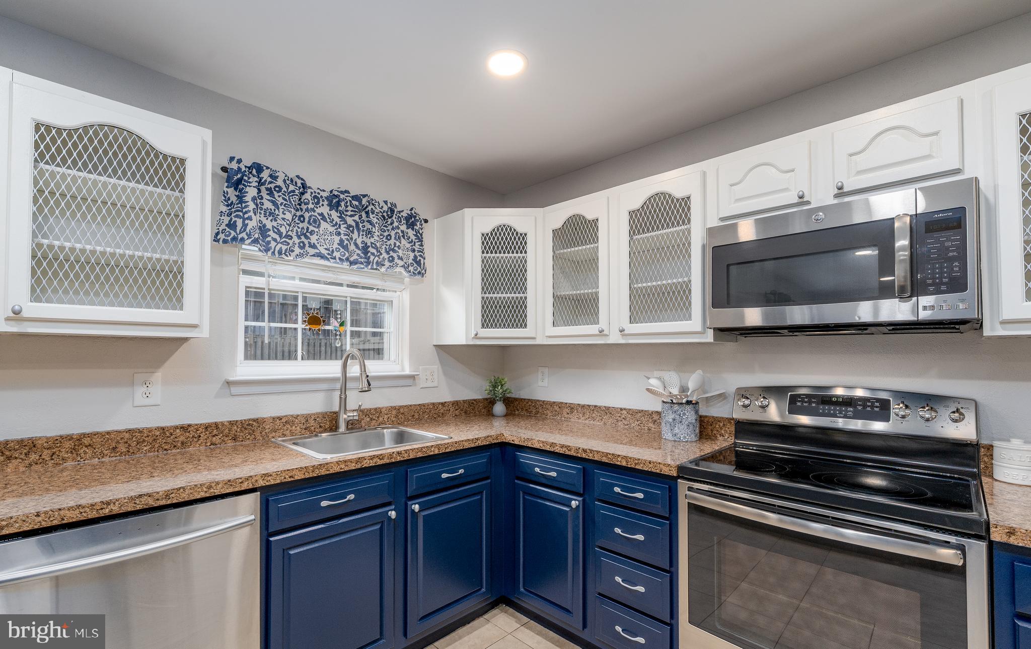 7815 Outing Avenue Pasadena, MD 21122 - Photo 12 of 37 a kitchen with stainless steel appliances granite countertop a sink and a stove