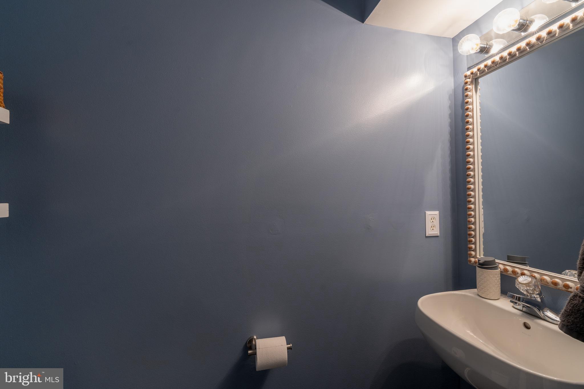 7815 Outing Avenue Pasadena, MD 21122 - Photo 13 of 37 a bathroom with a sink a toilet and a mirror