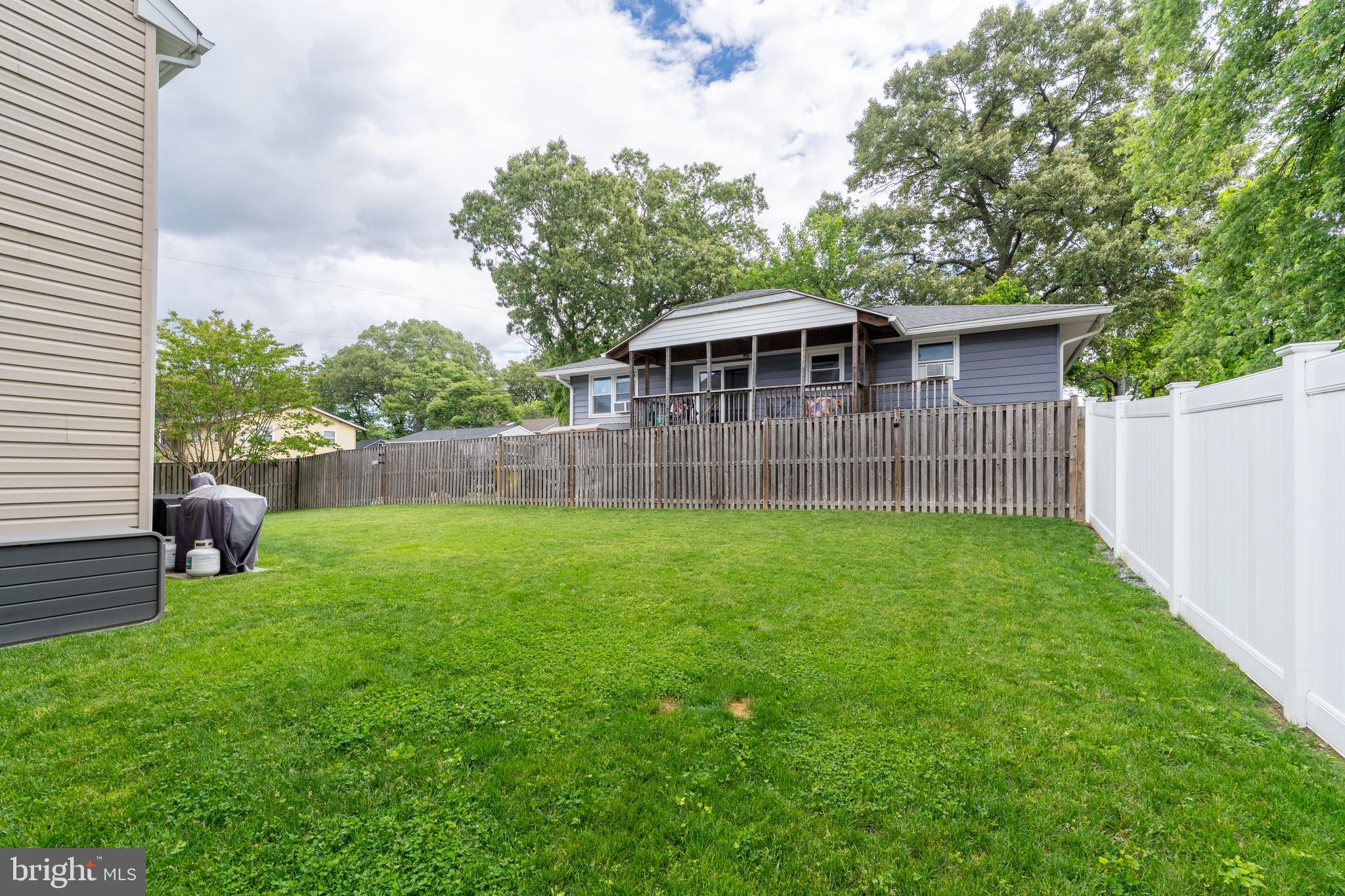 7815 Outing Avenue Pasadena, MD 21122 - Photo 28 of 37 a view of a yard with a table and chairs under an umbrella