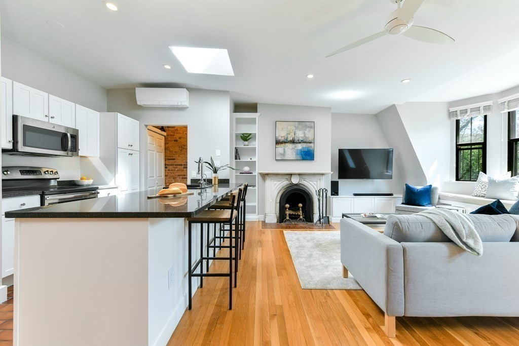 27 Concord Square, Unit 4 Boston, MA 02118 - Photo 3 of 8 a living room with furniture a flat screen tv and a fireplace