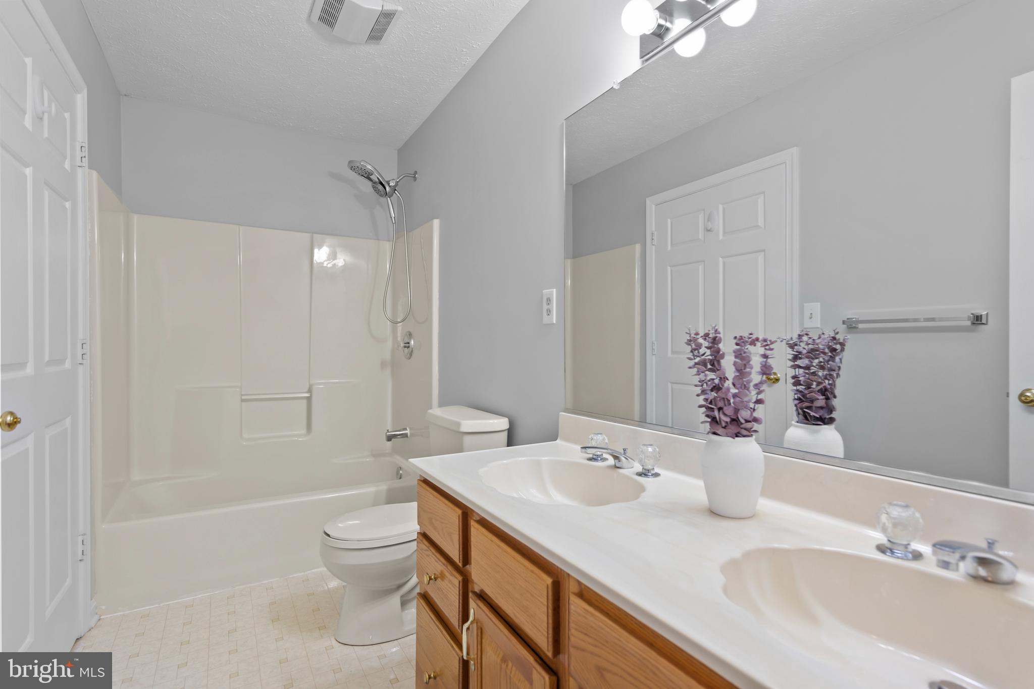 1039 Hiatt Road Clear Brook, VA 22624 - Photo 34 of 55 a bathroom with a granite countertop sink a toilet a mirror and shower