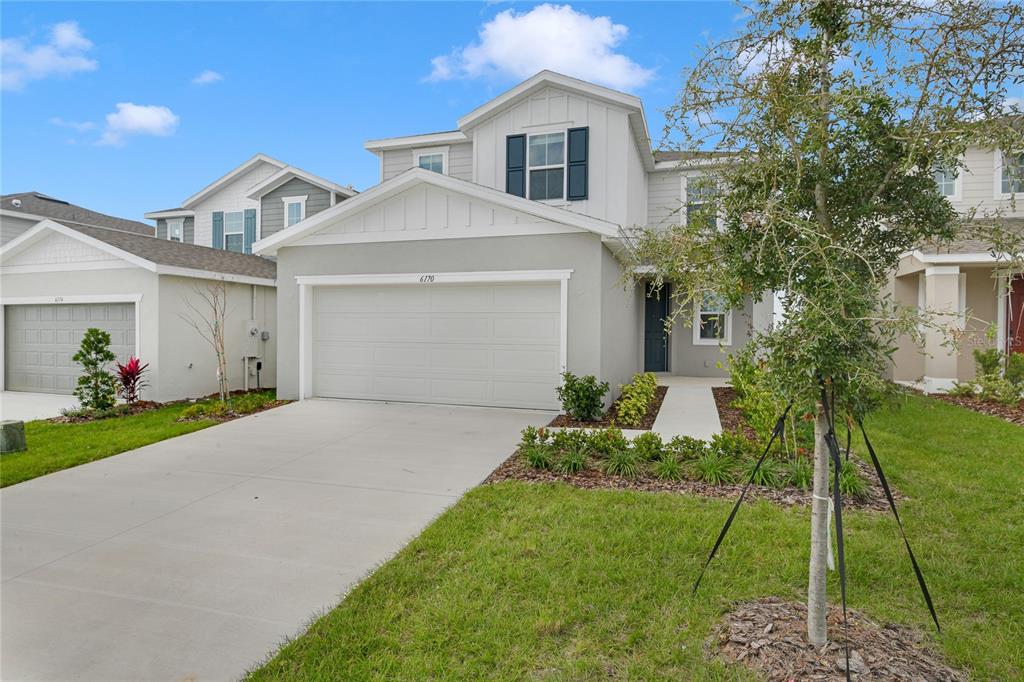 a front view of a house with a yard and potted plants