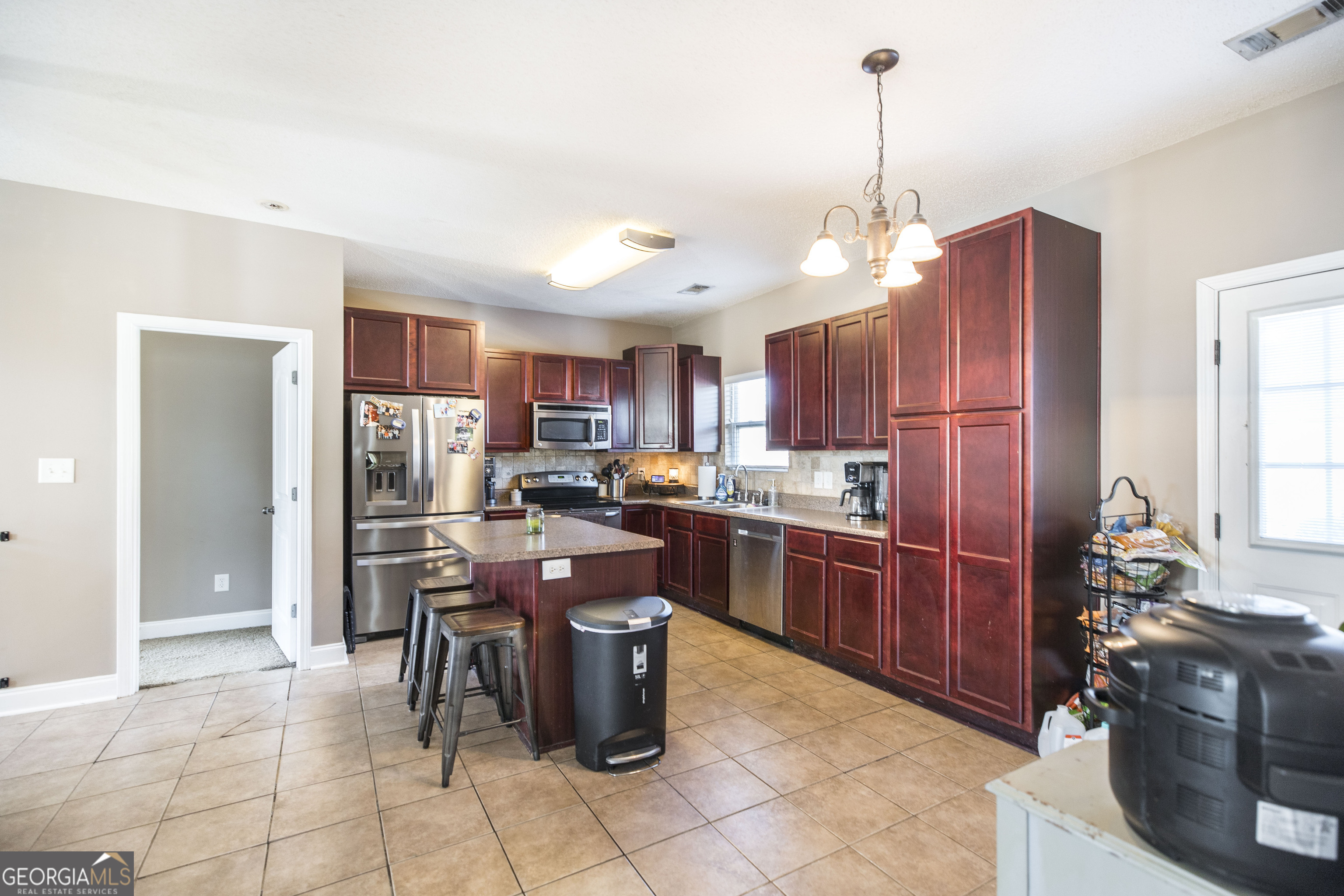 303 Rose Pointe Court Bonaire, GA 31005 - Photo 11 of 31 a open kitchen with stainless steel appliances granite countertop a stove top oven a refrigerator a sink a dining table and chairs with the wooden floor
