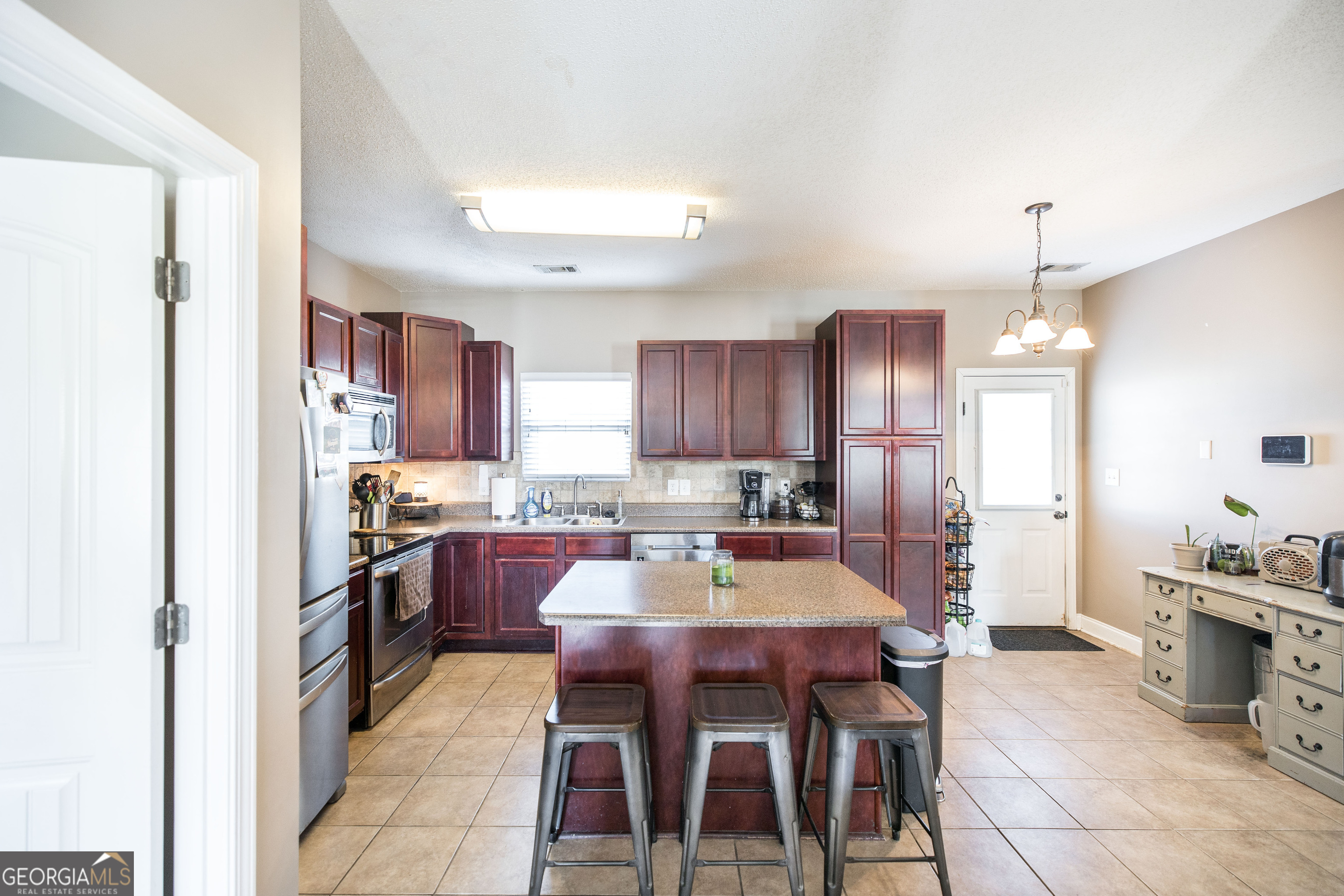 303 Rose Pointe Court Bonaire, GA 31005 - Photo 7 of 31 a kitchen with a dining table chairs and refrigerator