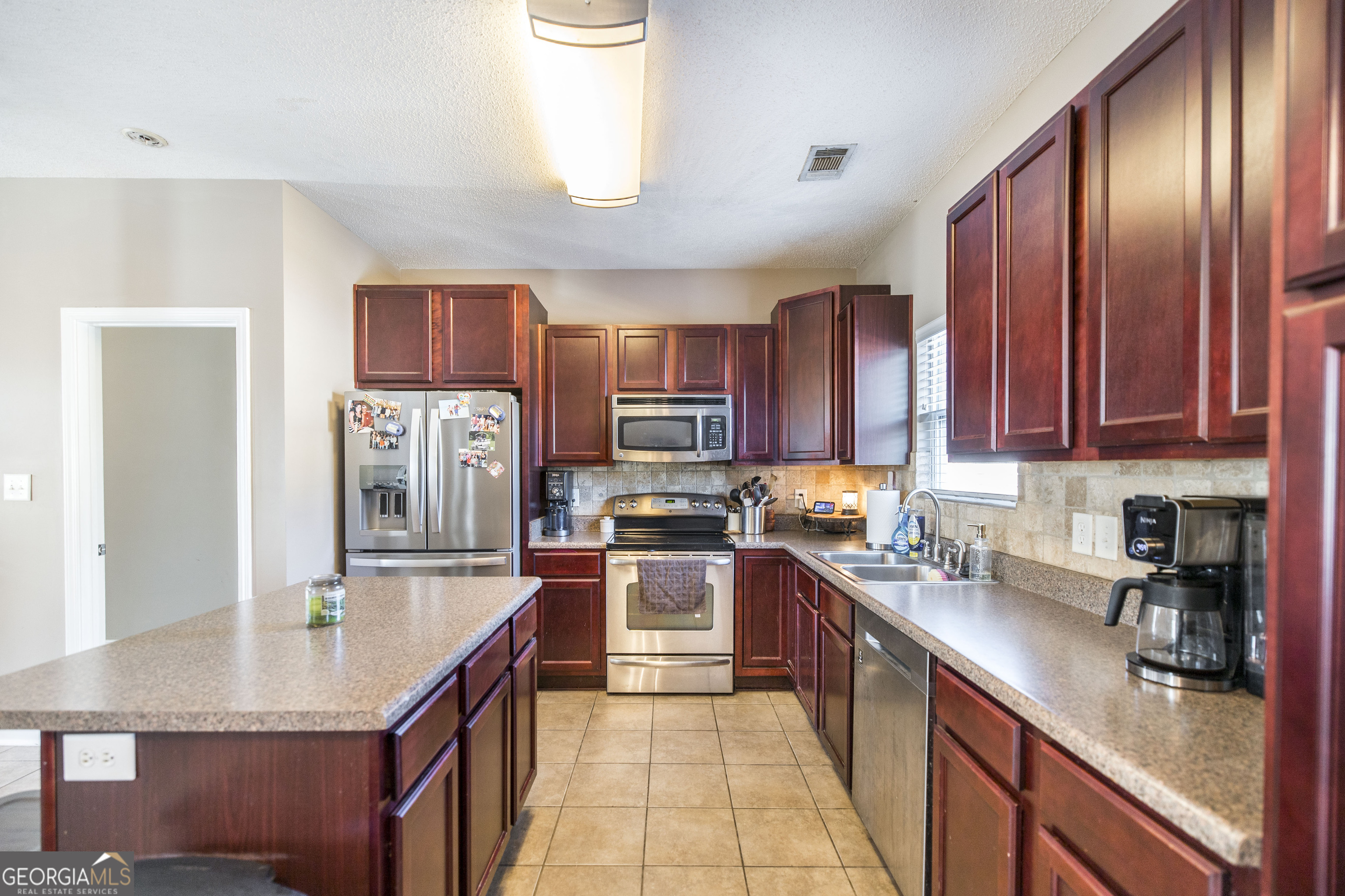 303 Rose Pointe Court Bonaire, GA 31005 - Photo 10 of 31 a kitchen with stainless steel appliances granite countertop a sink stove refrigerator and cabinets