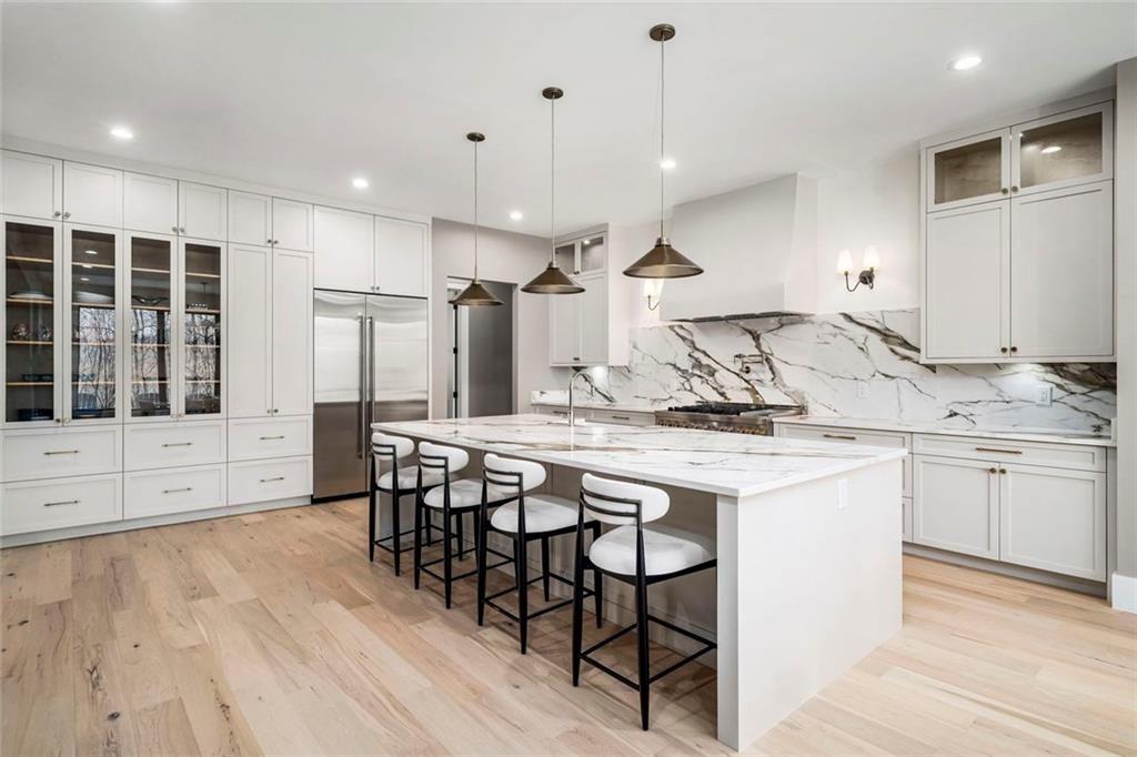 2309 Dinsmore Road Milton, GA 30004 - Photo 12 of 87 a kitchen with stainless steel appliances granite countertop a stove a refrigerator a sink and white cabinets with wooden floor
