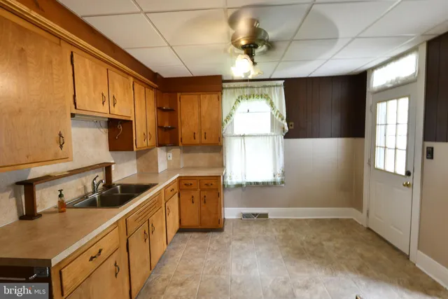 a kitchen with stainless steel appliances granite countertop a sink a stove cabinets counter space and a window