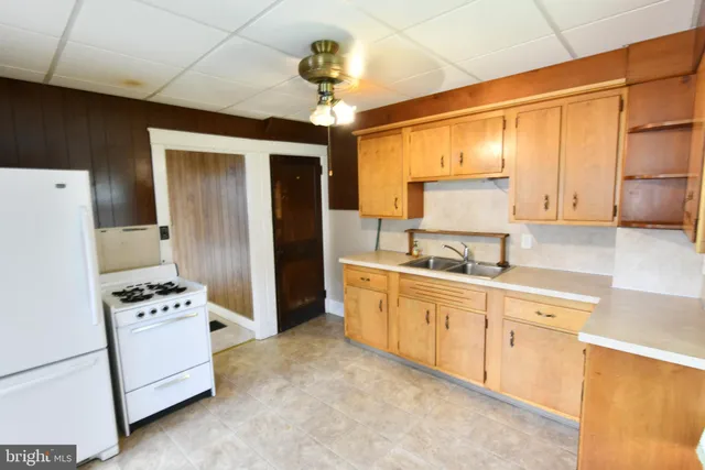a kitchen with granite countertop a refrigerator and a sink