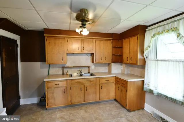 a kitchen with a sink appliances cabinets and furniture