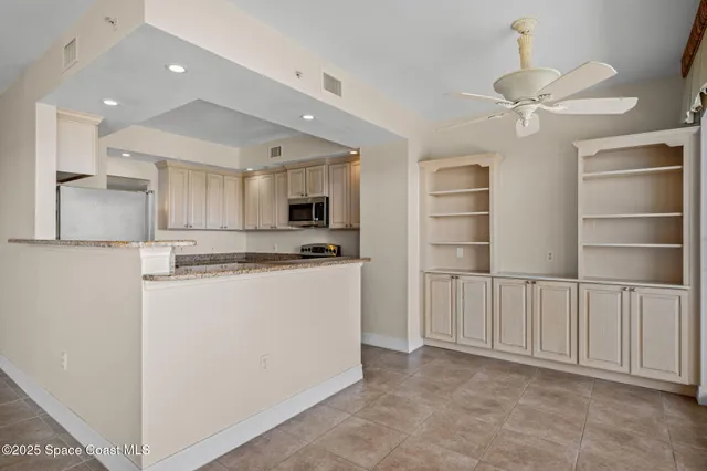 a kitchen with stainless steel appliances a refrigerator and white cabinets