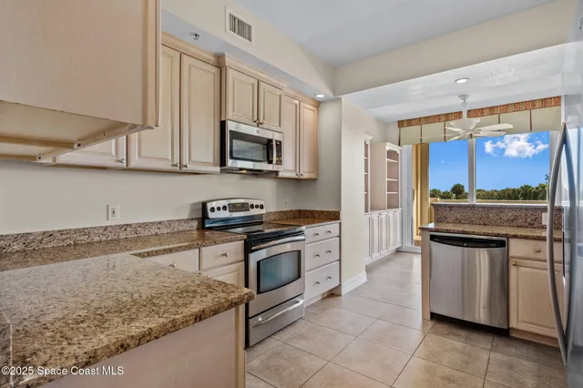 a kitchen with stainless steel appliances granite countertop a refrigerator a sink and a stove