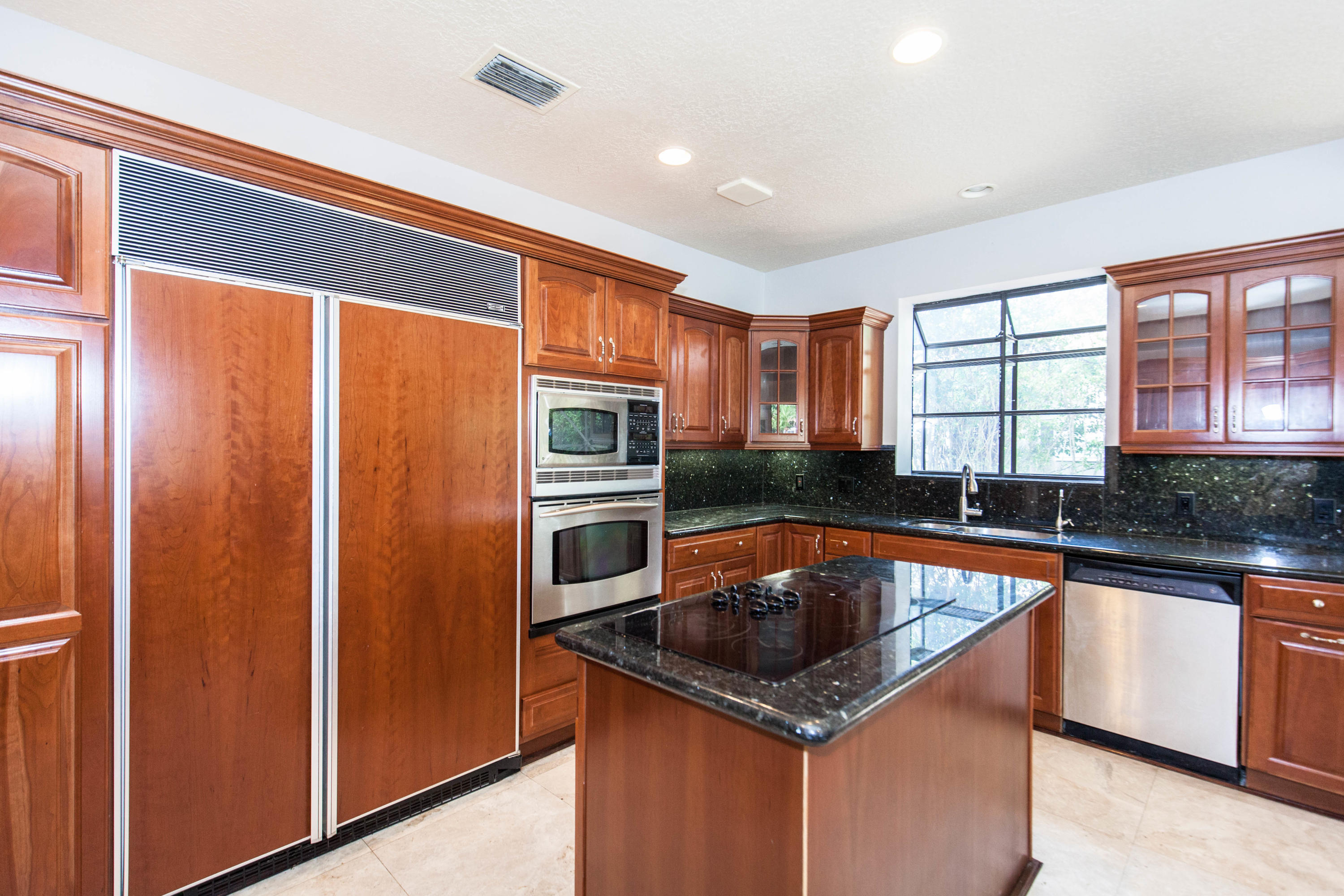 6087 Northwest 23rd Terrace Boca Raton, FL 33496 - Photo 13 of 64 a kitchen that has a sink and a stove in it