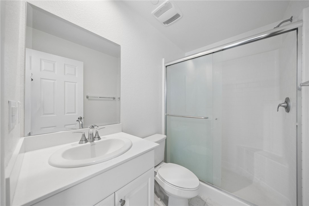 20130 Curaco Court Riverside, CA 92507 - Photo 20 of 43 Full bathroom with a white vanity and enclosed shower.