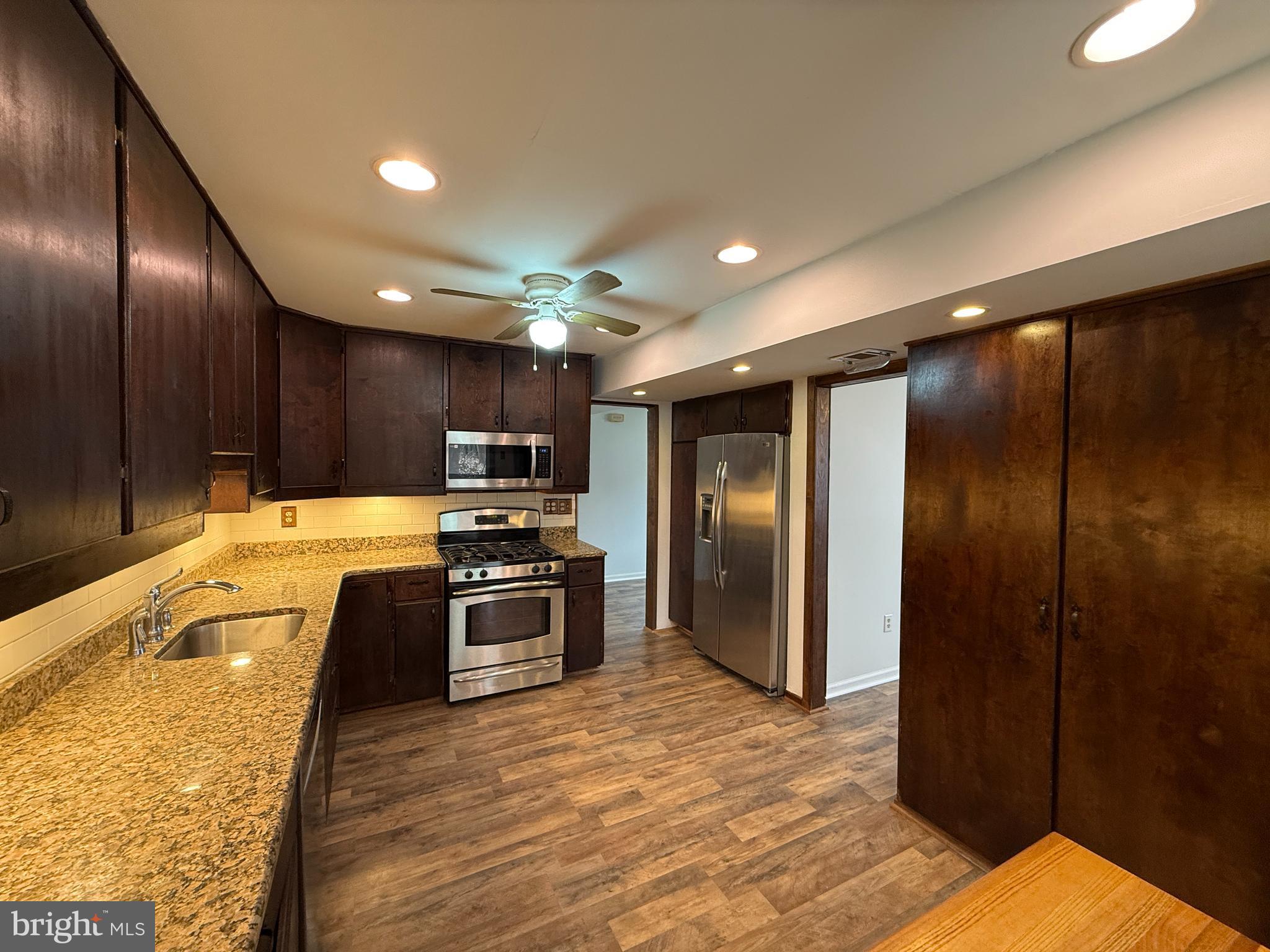6710 Red Jacket Road Springfield, VA 22152 - Photo 11 of 53 a large kitchen with stainless steel appliances kitchen island granite countertop a refrigerator and a sink