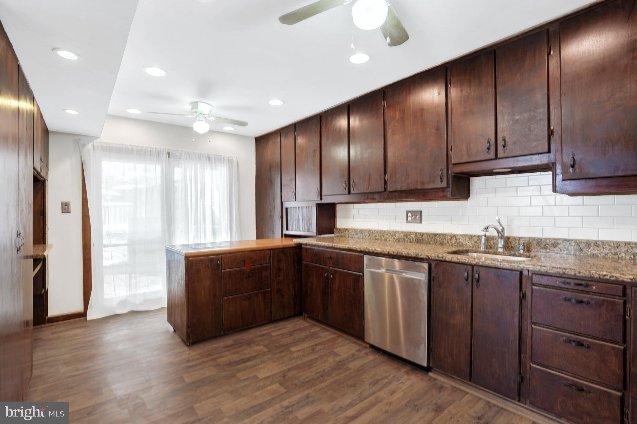 6710 Red Jacket Road Springfield, VA 22152 - Photo 19 of 53 a kitchen with granite countertop wooden cabinets a sink and stainless steel appliances