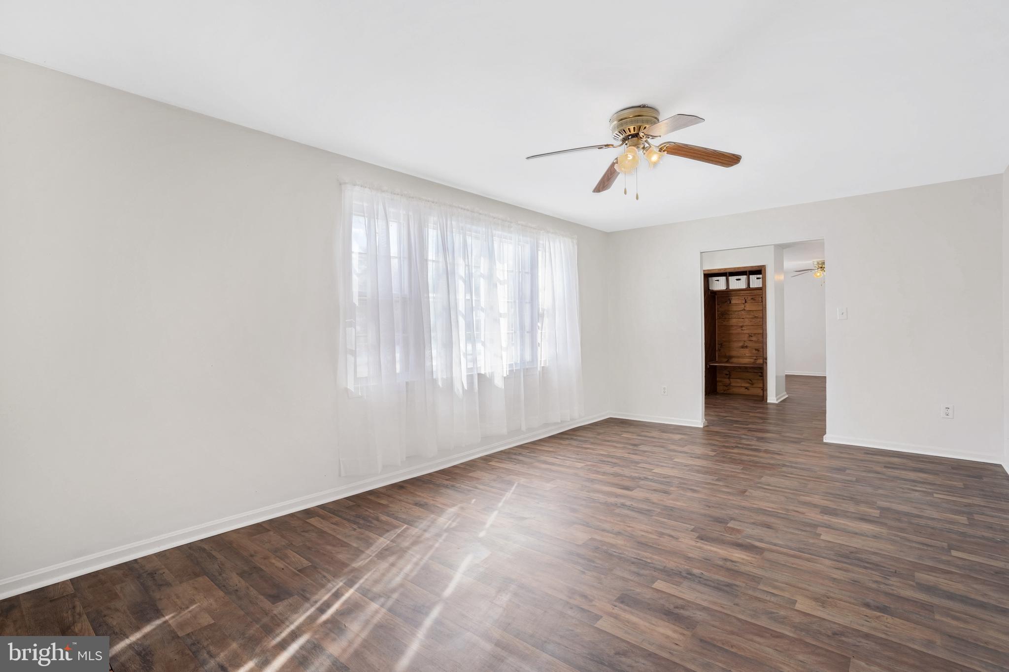6710 Red Jacket Road Springfield, VA 22152 - Photo 4 of 53 an empty room with wooden floor ceiling fan and windows