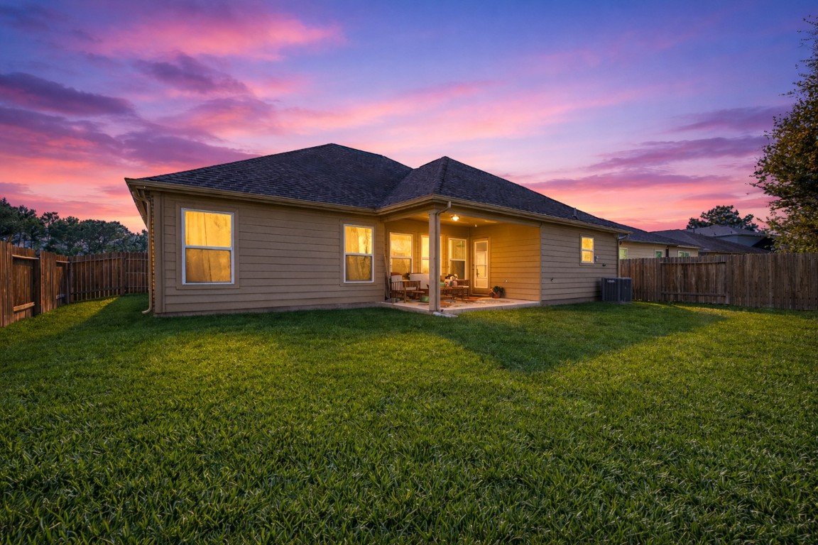9022 Nina Road Conroe, TX 77304 - Photo 13 of 13 Evenings come alive in this peaceful backyard—open, inviting, and perfect for unwinding under the sunset sky.