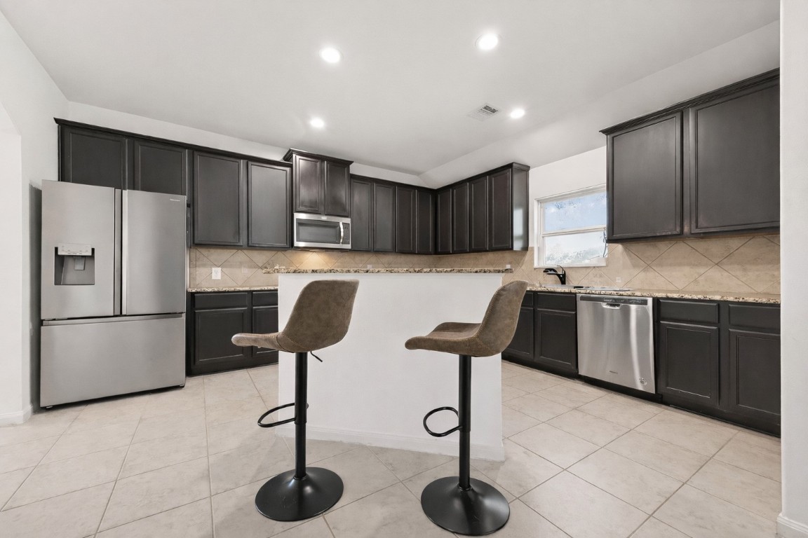 9022 Nina Road Conroe, TX 77304 - Photo 5 of 13 Sleek, modern, and functional—the kitchen is designed to bring people together around its generous island.