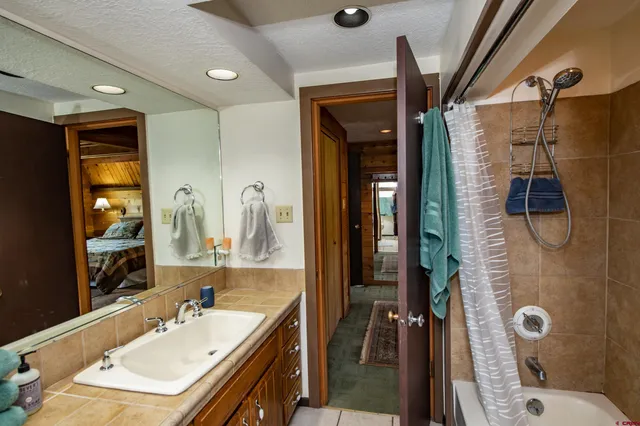 a spacious bedroom with a bed and a flat screen tv