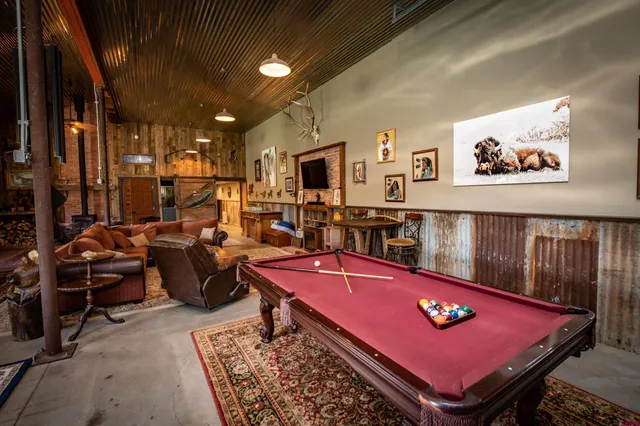 a bedroom with a bed a table and chair with wooden floor