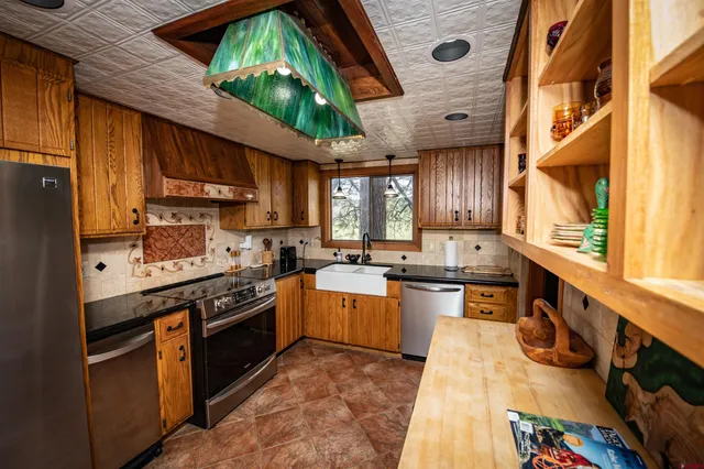 a kitchen with stainless steel appliances granite countertop a stove a sink dishwasher and cabinets with wooden floor