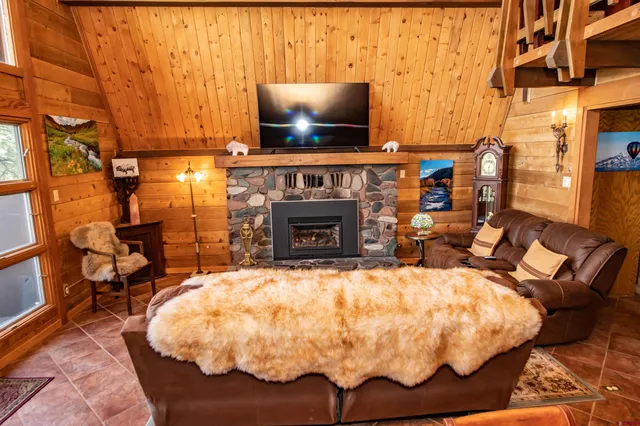 a bed sitting in a living room with a flat screen tv and a fireplace