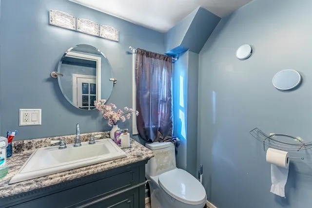 a bathroom with a toilet sink and mirror