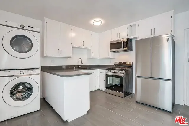 a kitchen with a refrigerator sink and cabinets
