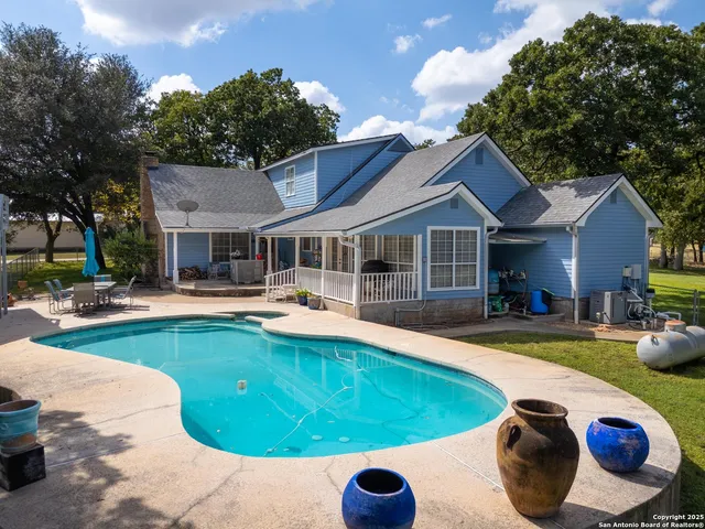 a swimming pool with outdoor seating and yard