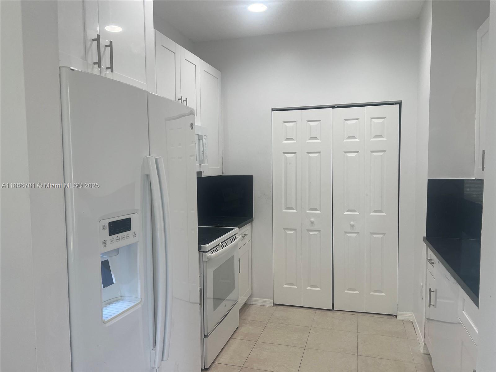4287 Northeast 9th Street Homestead, FL 33033 - Photo 13 of 25 a view of a refrigerator in kitchen and white cabinets
