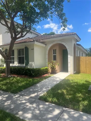 a living room with patio furniture and a garden