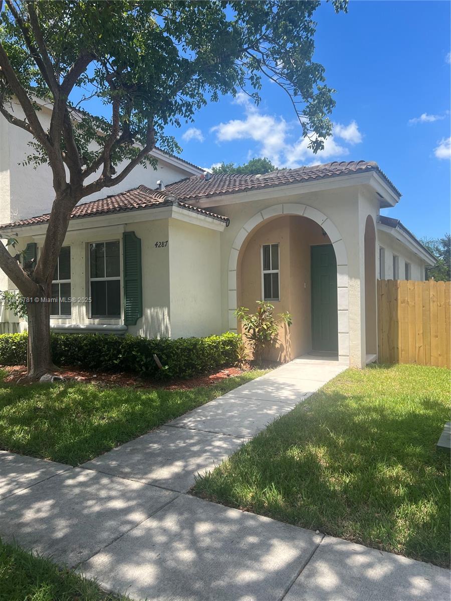4287 Northeast 9th Street Homestead, FL 33033 - Photo 21 of 25 a front view of a house with a garden and yard