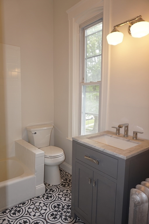 73 Elm Road, Unit 8 Newton, MA 02460 - Photo 9 of 12 a bathroom with a sink toilet vanity and window