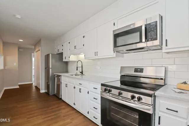 a kitchen with stainless steel appliances a stove microwave and refrigerator