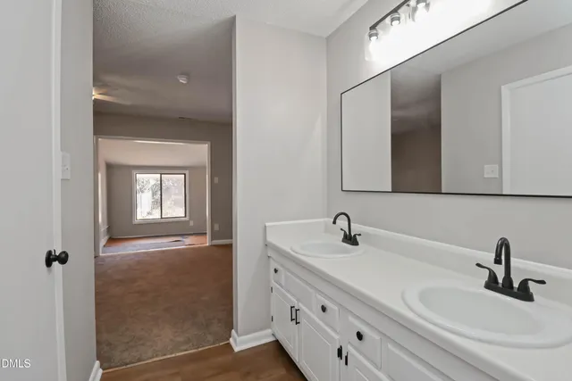 a bathroom with double vanity sink and a mirror