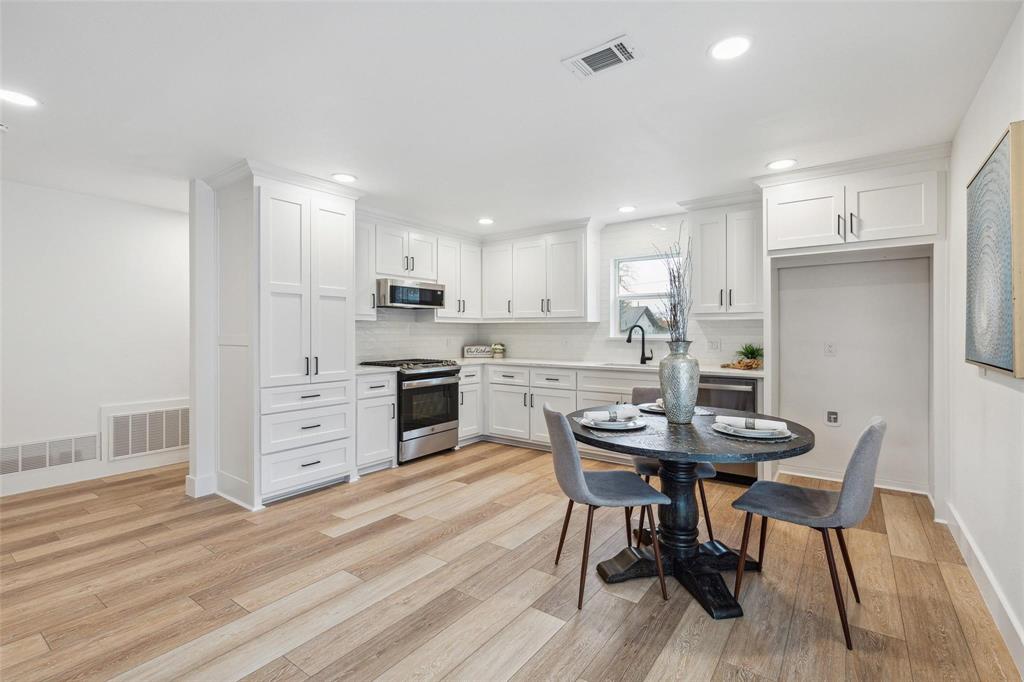 7274 Pecan Street Frisco, TX 75034 - Photo 3 of 13 a kitchen with stainless steel appliances kitchen island granite countertop a table chairs and a refrigerator