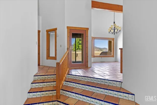 an empty room with wooden floor staircase and windows