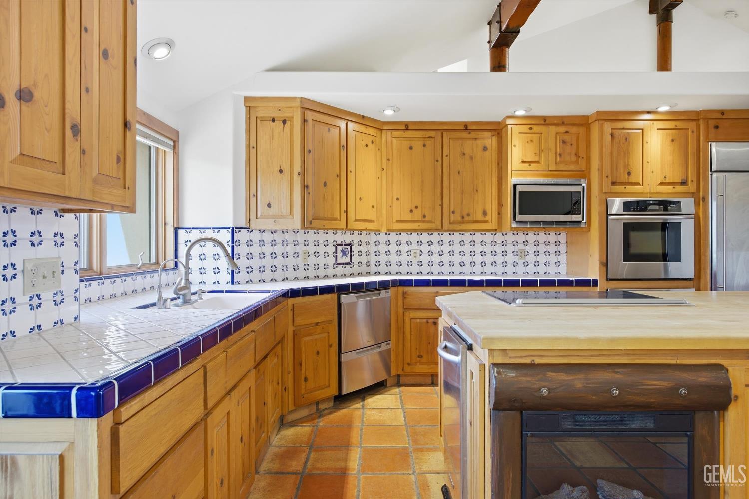 Undisclosed Address Tehachapi, CA 93561 - Photo 21 of 70 a kitchen with stainless steel appliances granite countertop a sink and cabinets