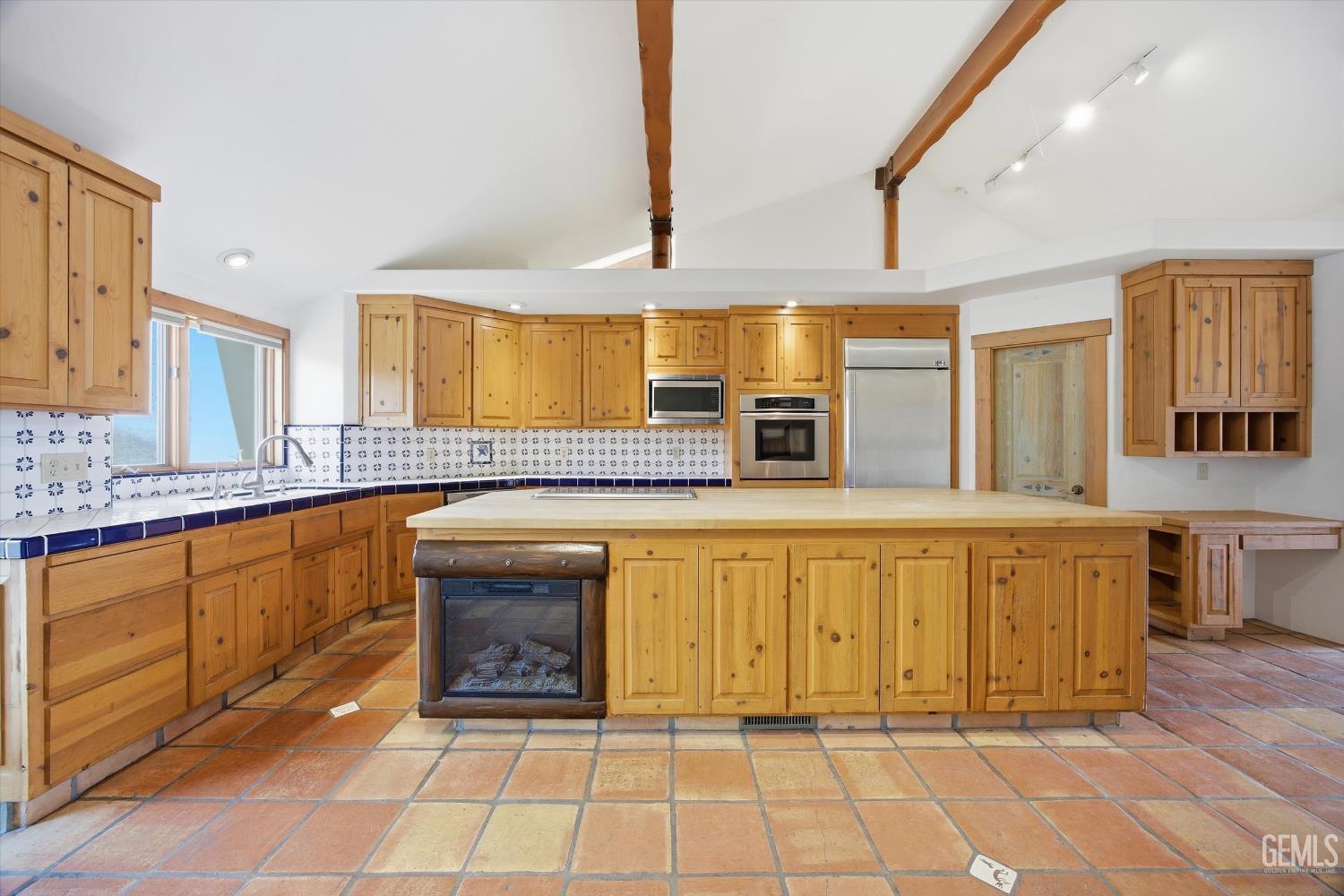 Undisclosed Address Tehachapi, CA 93561 - Photo 22 of 70 a large kitchen with granite countertop a sink and cabinets