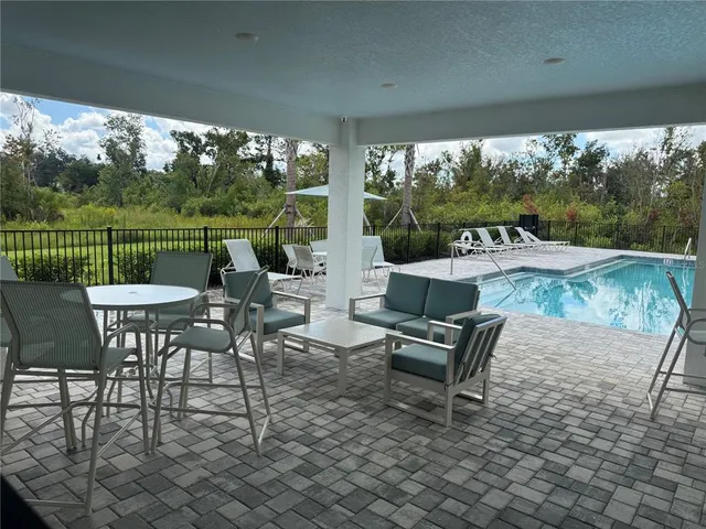 a view of a patio with a table chairs and a yard
