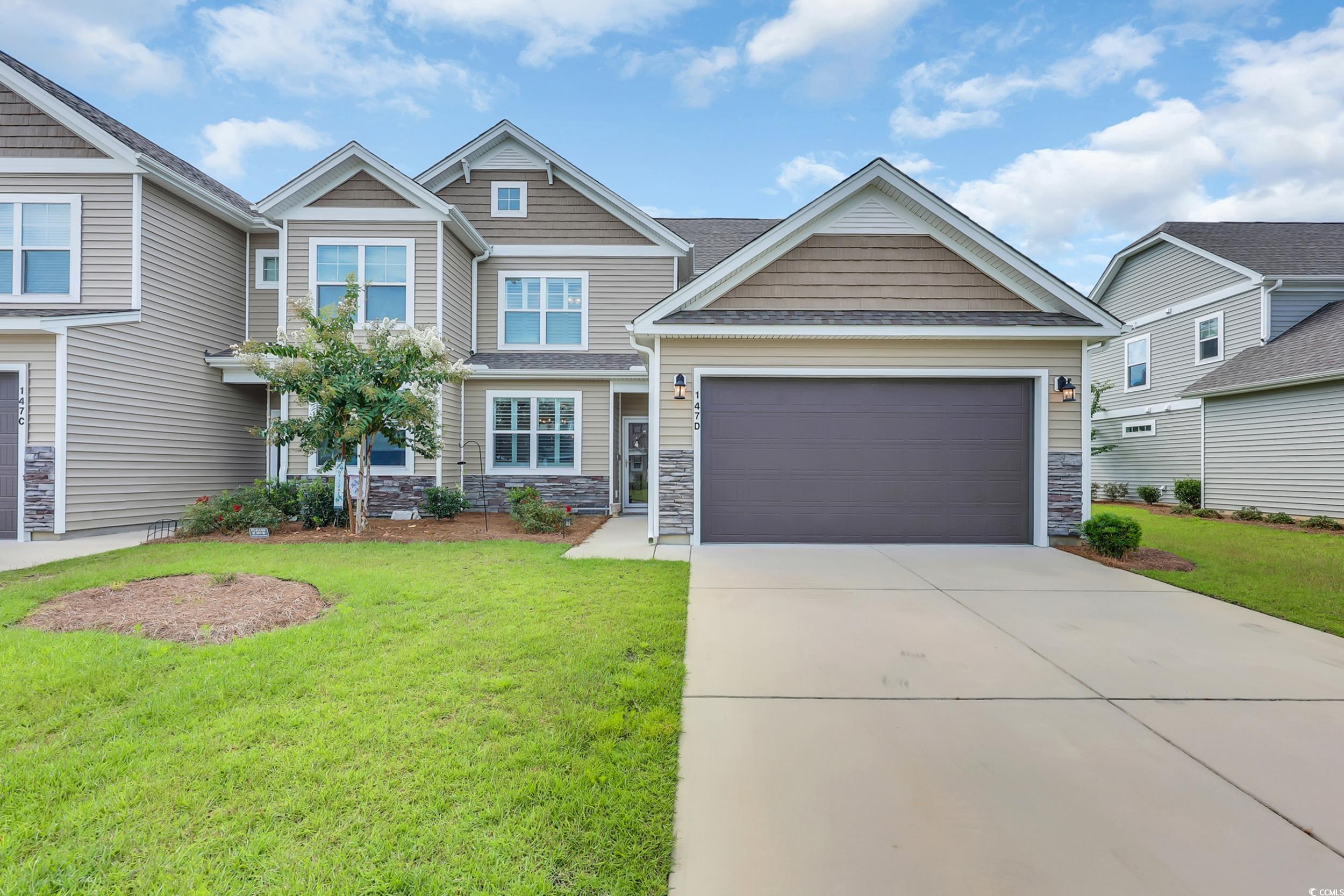 147 Machrie Loop, Unit D Myrtle Beach, SC 29588 - Photo 1 of 36 Craftsman-style house with stone siding, driveway, an attached garage, and a front yard