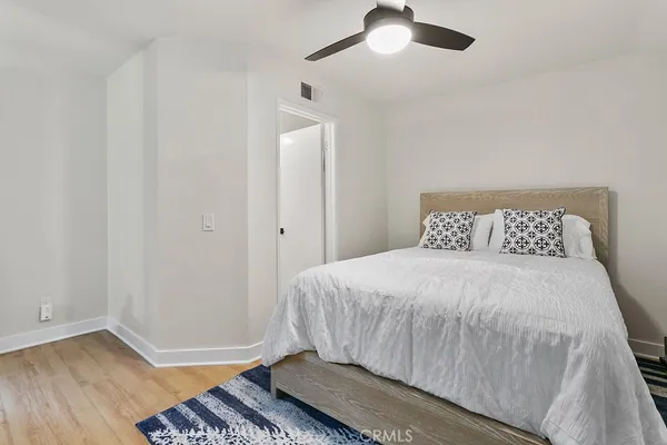 a bedroom with a bed and wooden floor