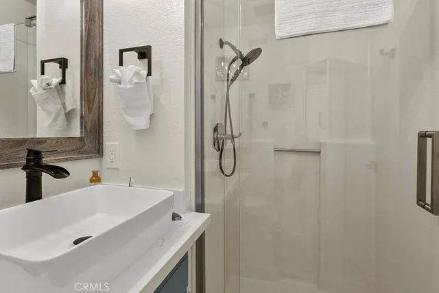 a bathroom with a sink vanity and shower