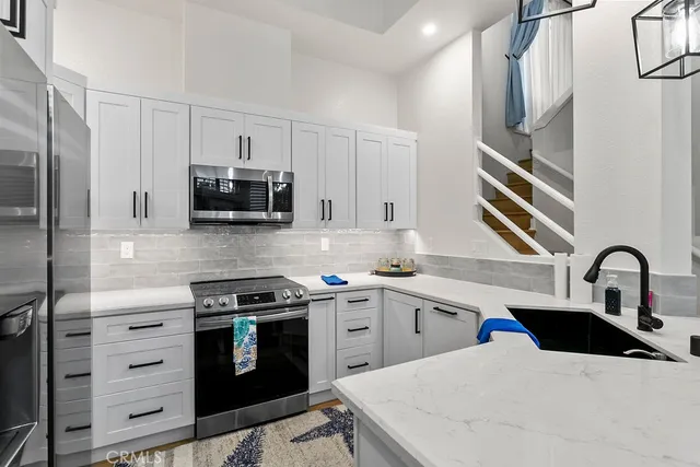 a kitchen with appliances a sink and cabinets