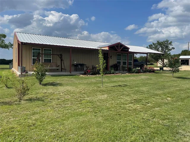 a view of a house with yard and sitting area