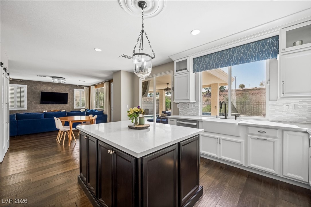 1673 Ravanusa Drive Henderson, NV 89052 - Photo 66 of 66 Kitchen with white cabinets, light stone countertops, open floor plan, a kitchen island, and recessed lighting