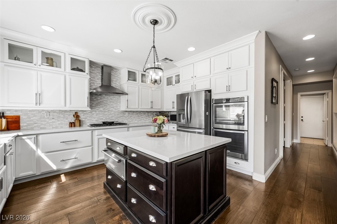1673 Ravanusa Drive Henderson, NV 89052 - Photo 13 of 66 Kitchen featuring stainless steel appliances, a kitchen island, white cabinets, dark wood finished floors, and recessed lighting