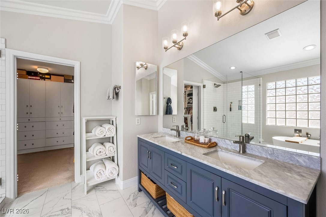 1673 Ravanusa Drive Henderson, NV 89052 - Photo 32 of 66 Renovated primary bath with freestanding tub and seperate shower, dual vanities with marble counters and walk in closet